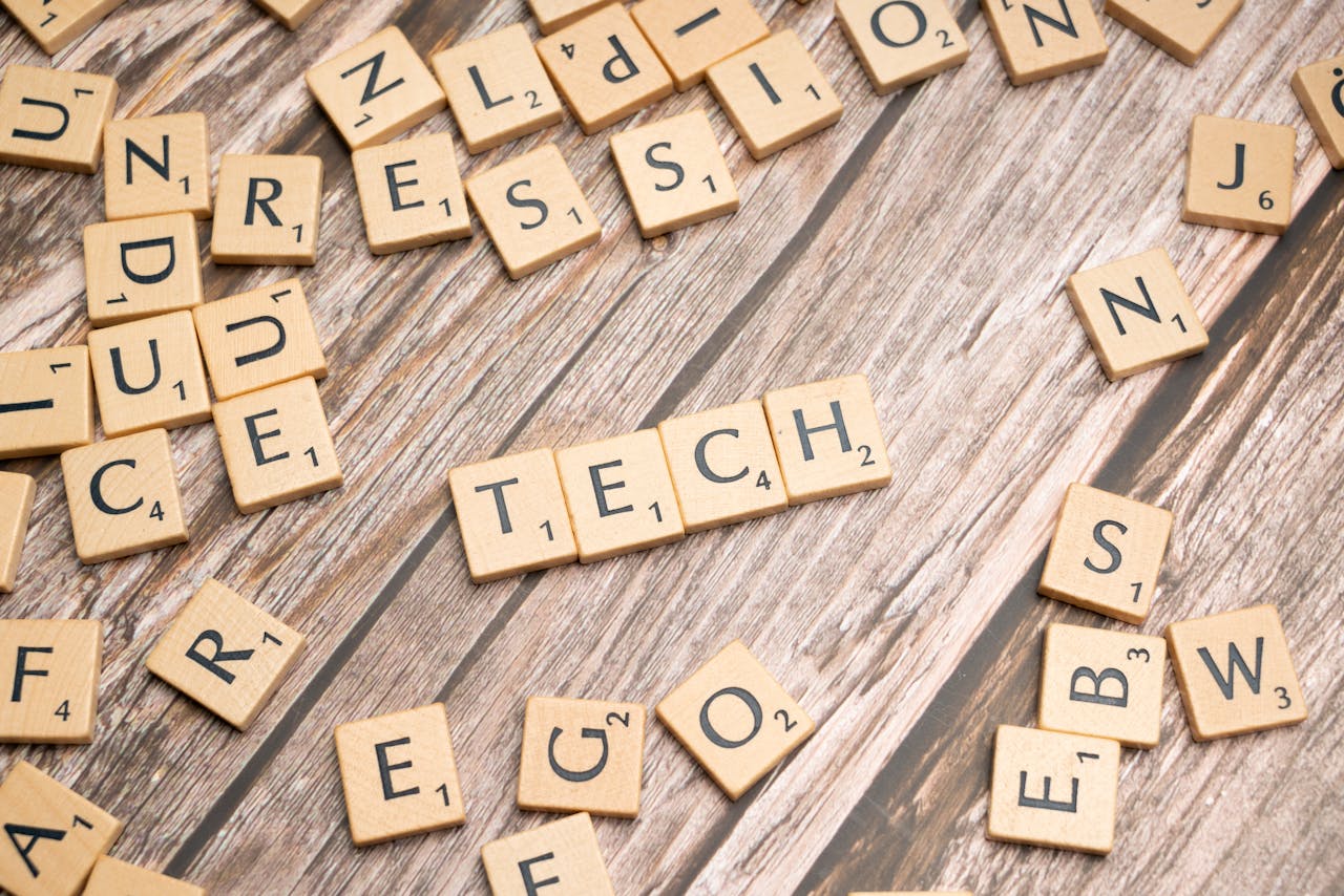 Scrabble letters spelling out tech on a wooden table